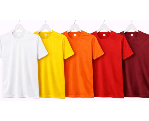 Six t-shirts in white, yellow, orange, red, crimson, and burgundy hung on white hangers from left to right. -