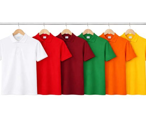 Row of colorful polo shirts hanging on a metal rod, from white to yellow, on wooden hangers. -